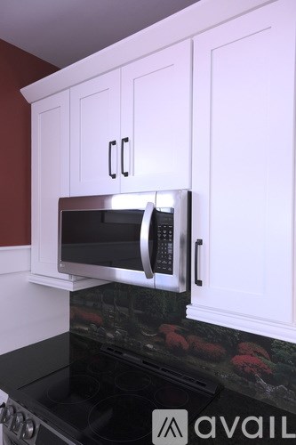 A microwave is built into a kitchen cabinet.