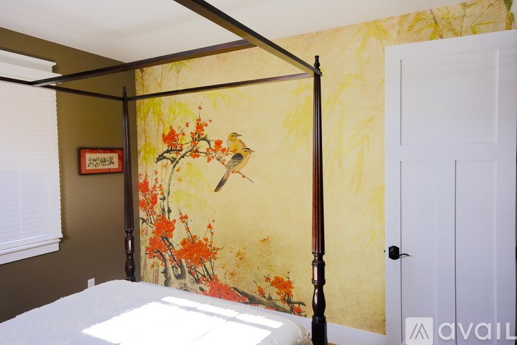 A room with a yellow floral wallpaper and a white door.