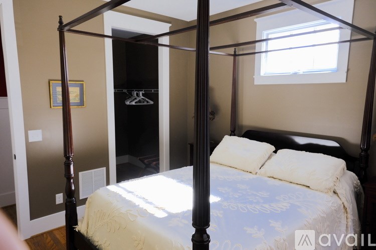 A bedroom with a four poster bed and a window.
