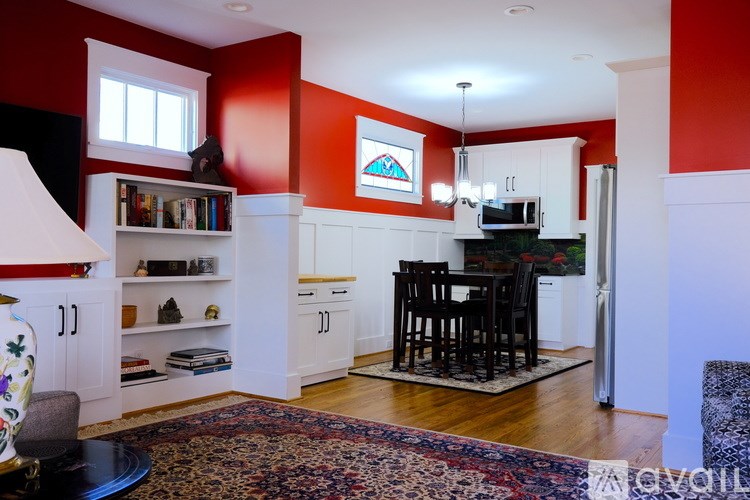 A kitchen with red walls and white cabinets.