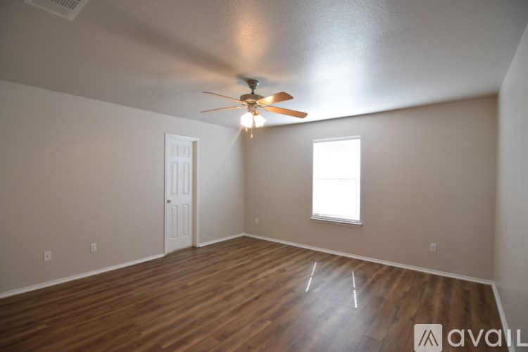 A spacious room with wooden floors and white walls.