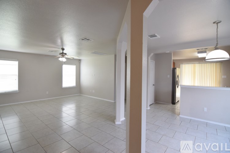 A spacious room with wooden floors and white walls.