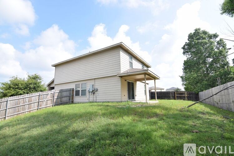 A house with a fence and a green lawn in front.