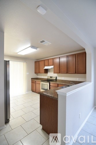 A kitchen with brown cabinets and white appliances.