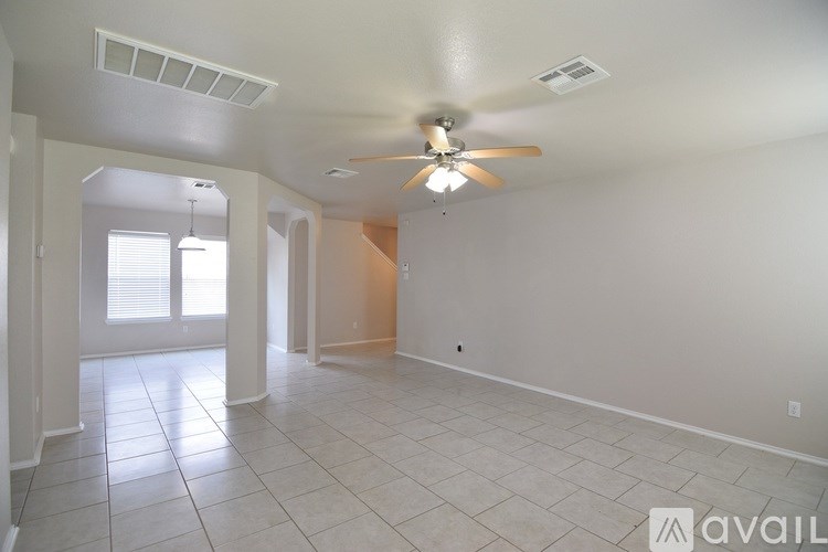 A spacious room with a ceiling fan and tiled flooring.