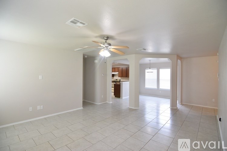 A spacious living room with a ceiling fan and sliding glass doors.