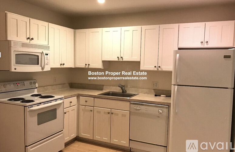 A kitchen with white appliances and cabinets.