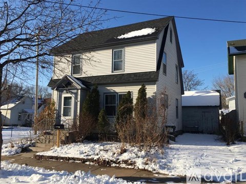A house with snow on the roof and ground.