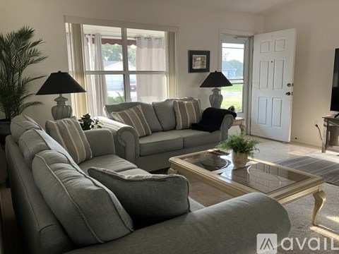 A living room with a grey sofa and a glass coffee table.