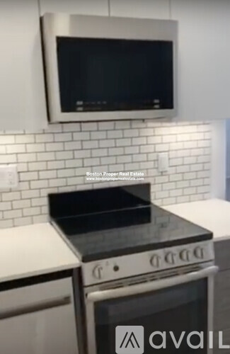 A modern kitchen with a stove top oven and microwave above it.