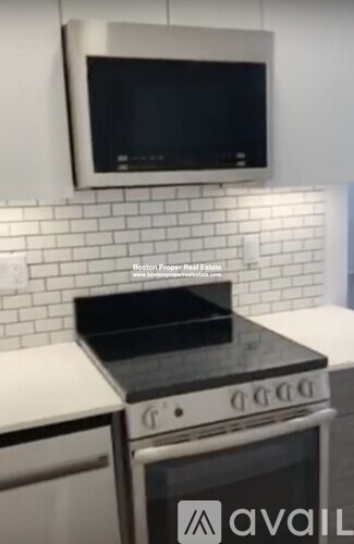 A modern kitchen with a stove top oven and microwave above it.