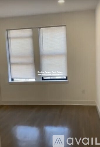 A room with a window and a sign that says "Boston Property Real Estate".