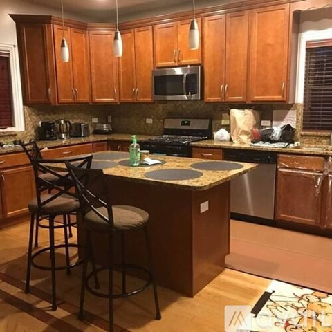 A kitchen with wooden cabinets and a granite countertop.