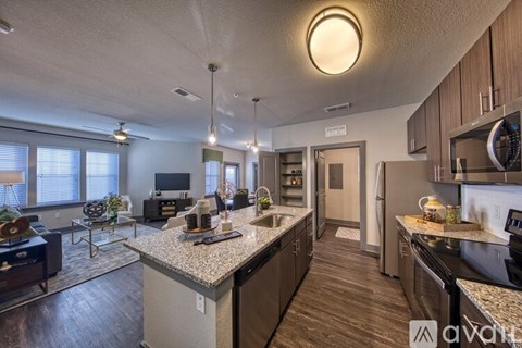 A well-lit kitchen with a dining area and a living room.
