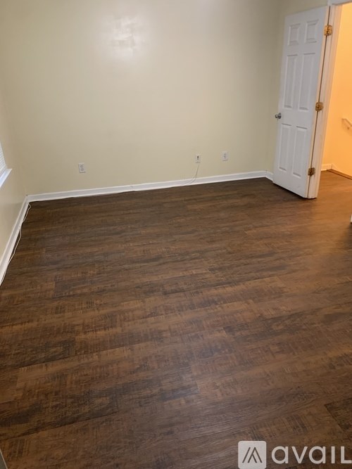 A room with wooden flooring and a white door.