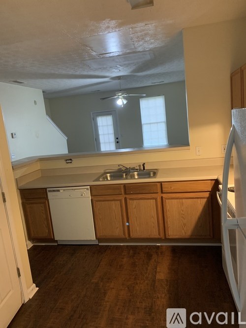 A kitchen with wooden cabinets and a white dishwasher.