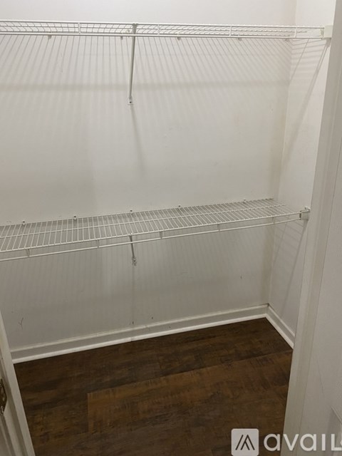 Empty white shelving unit with a wooden floor.