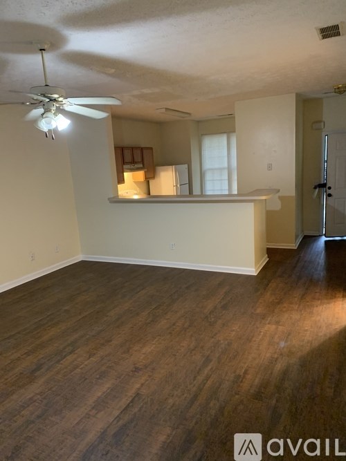 A room with a ceiling fan and wooden flooring.