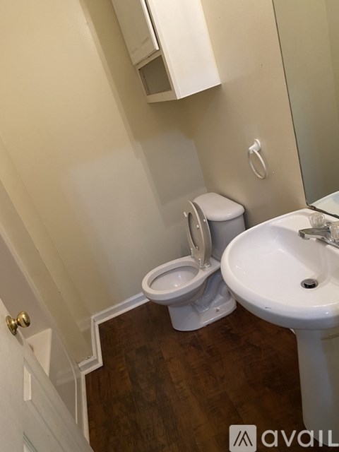 A white toilet and sink in a small bathroom.