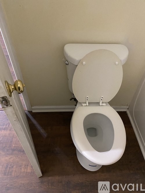 A white toilet with a closed lid and open seat in a bathroom.