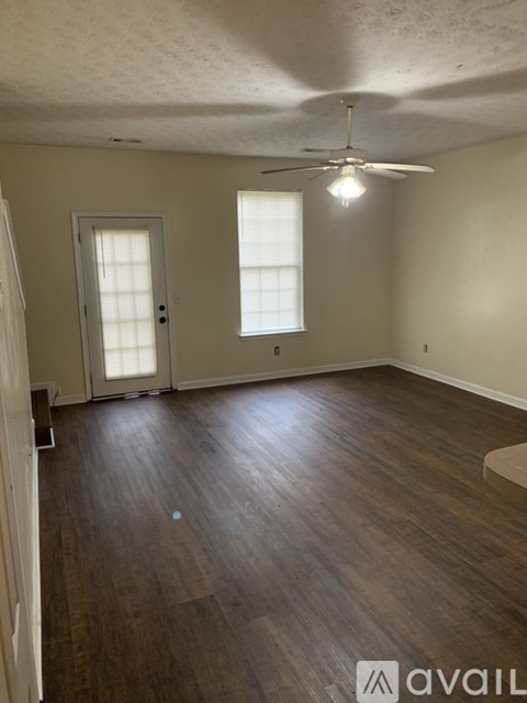 A room with wooden floors and a ceiling fan.