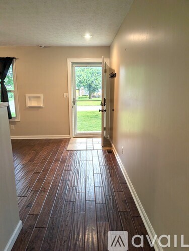 A room with a white counter and wooden floors.