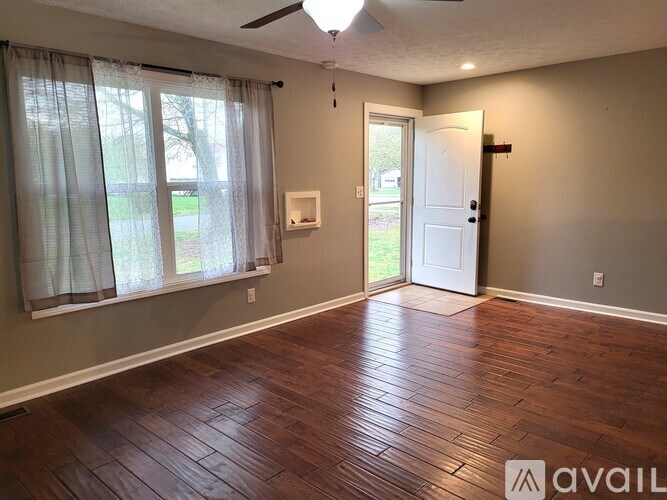 A room with a wooden floor and a ceiling fan.
