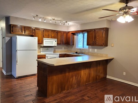 A kitchen with wooden cabinets and a white refrigerator.