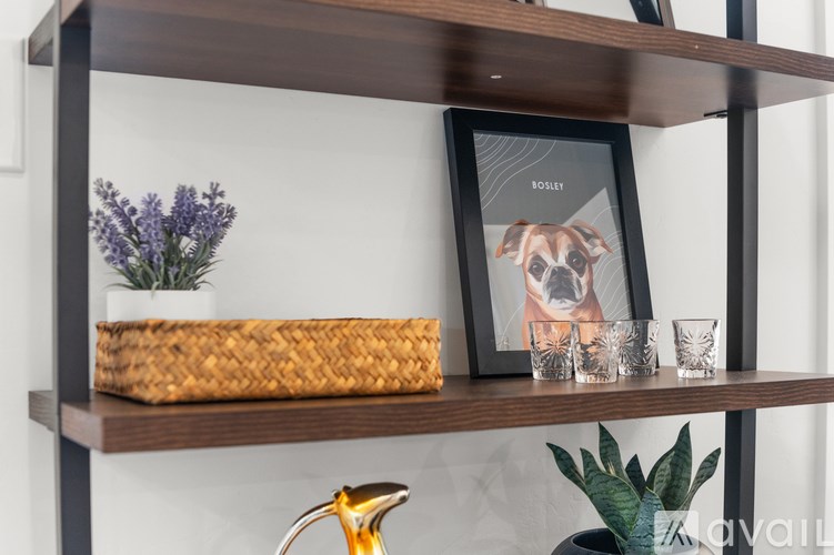 A shelf with a picture frame, a basket, and glasses on it.