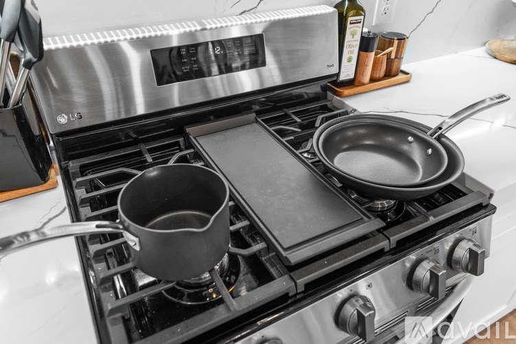 A stainless steel stove with a pot and a frying pan on it.