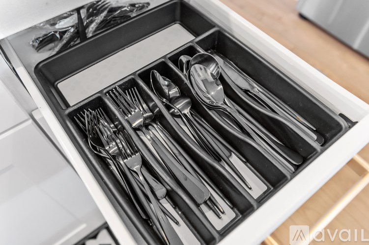 A set of silverware is neatly organized in a drawer.