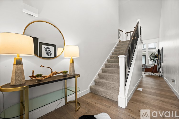 A staircase with a glass railing and a wooden handrail.