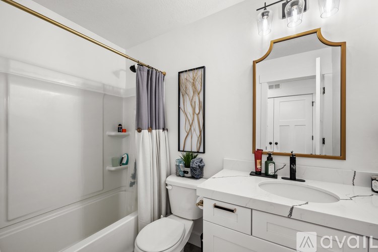A bathroom with a white toilet, sink, and bathtub.