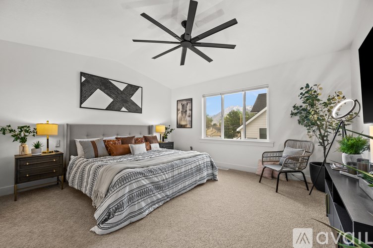 A bedroom with a large bed and a ceiling fan.