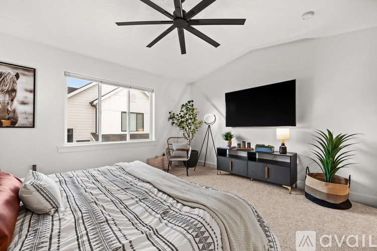A bedroom with a large bed and a flat screen TV mounted on the wall.
