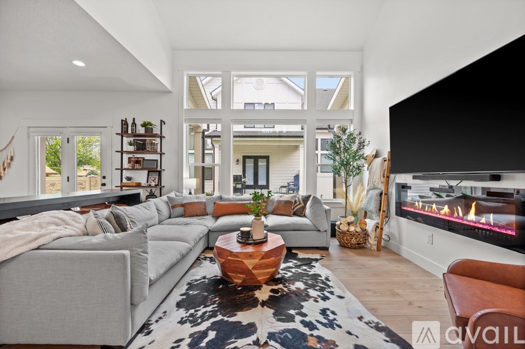 A modern living room with a grey sofa, a coffee table, and a fireplace.