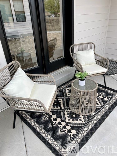 Two chairs and a table are on a patterned rug.