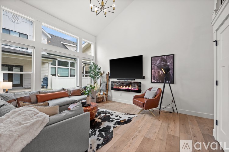 A living room with a grey couch and a black television.