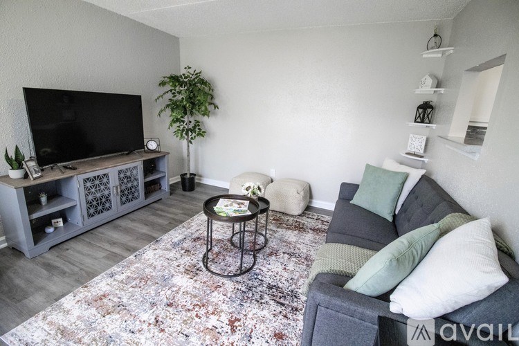 A living room with a grey couch, a coffee table, and a television.