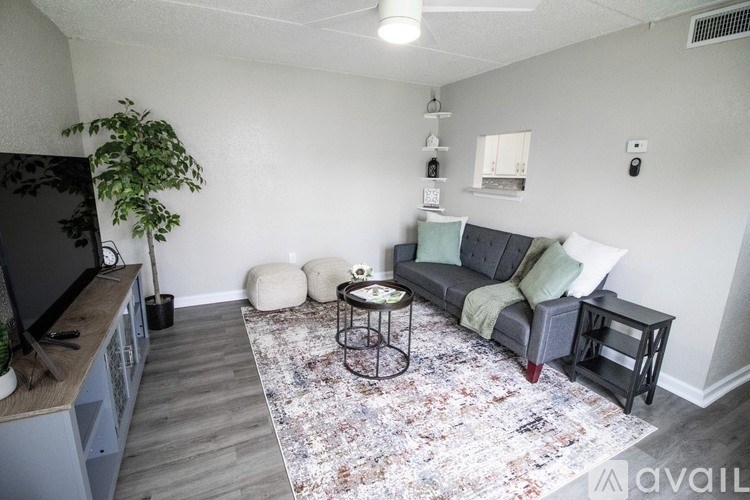 A living room with a grey couch, a small table, and a rug.