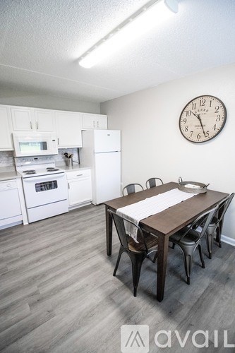 A kitchen with a table and chairs and a clock on the wall.