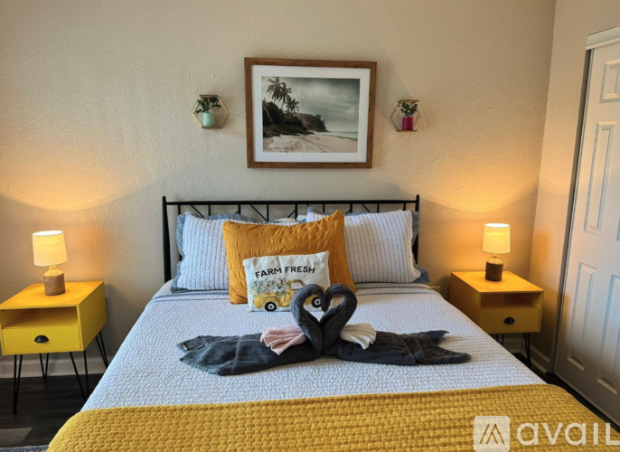 A bedroom with a bed, two lamps, and a picture on the wall.