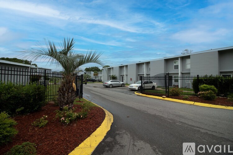 A street view of a residential area with apartment buildings and parked cars.