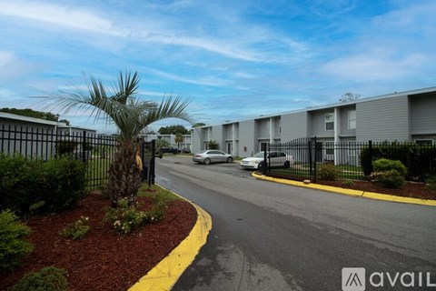 A street view of a residential area with apartment buildings and parked cars.