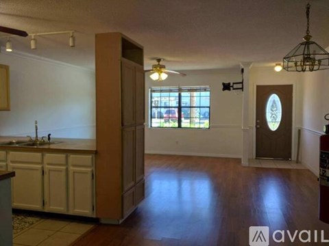 A kitchen with white cabinets and a sink is available for rent.