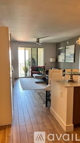 A kitchen with a white counter and a dining table with chairs.