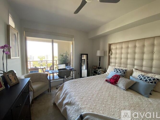 A bedroom with a large bed and a window overlooking a balcony.