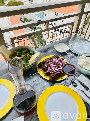 A table set for a meal with a view of a pool and buildings.