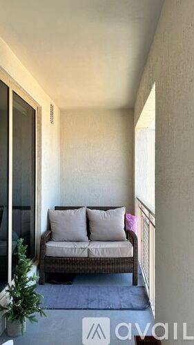 A balcony with a couch and a plant.