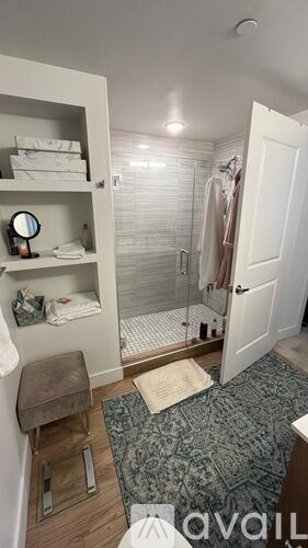 A bathroom with a white door and a mirror on the shelf.